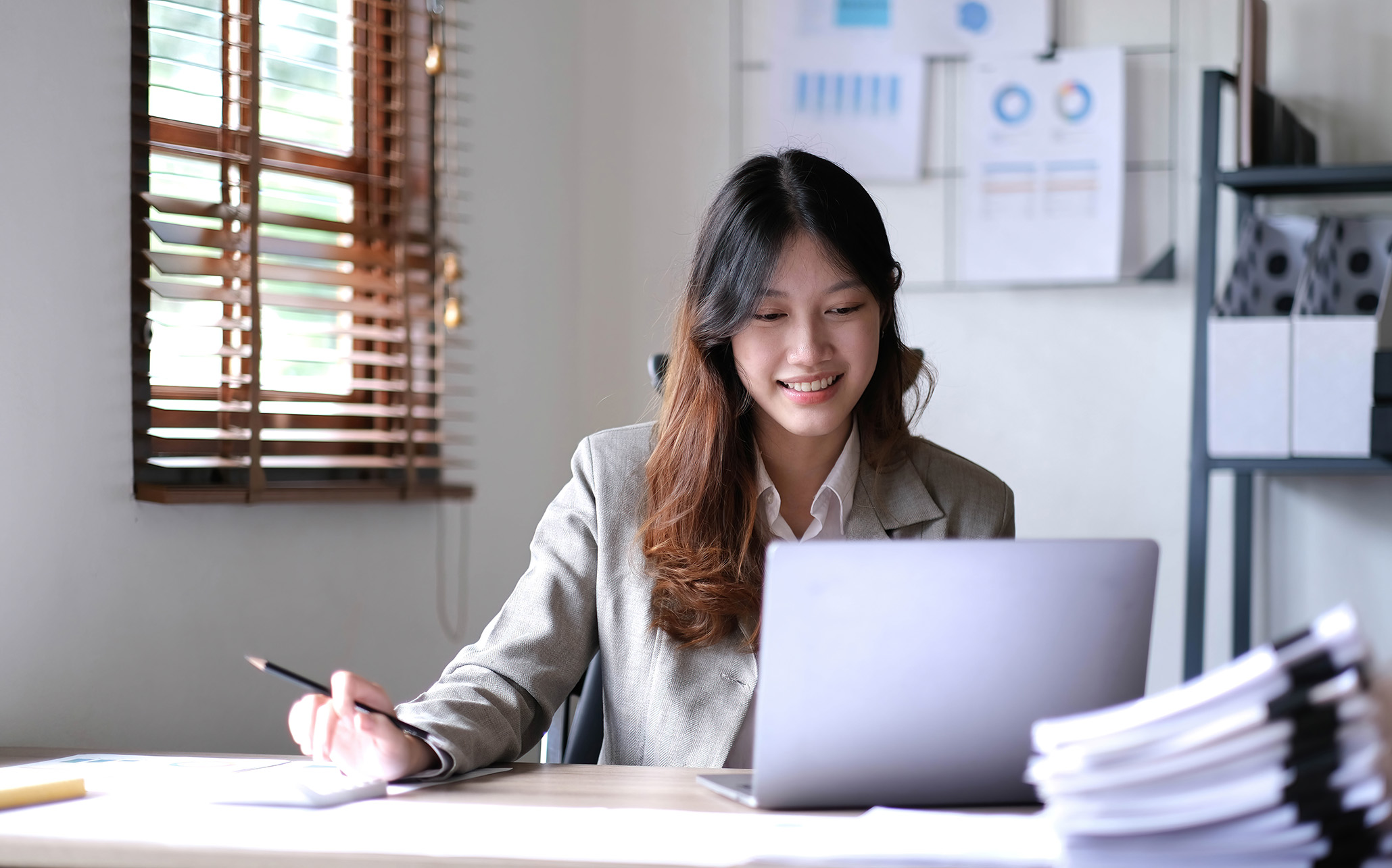 young-smiling-businesswoman-working-on-laptop - tinified